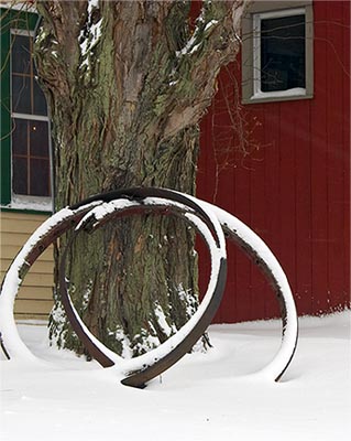 Two old wagon wheel hoops draped in the recent snow.